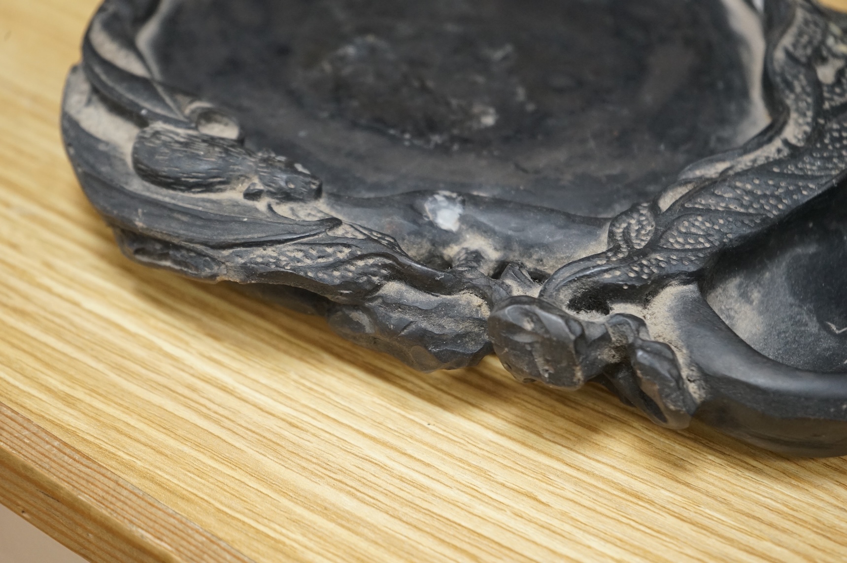 A Chinese carved inkstone, character marks to the base, 23cm